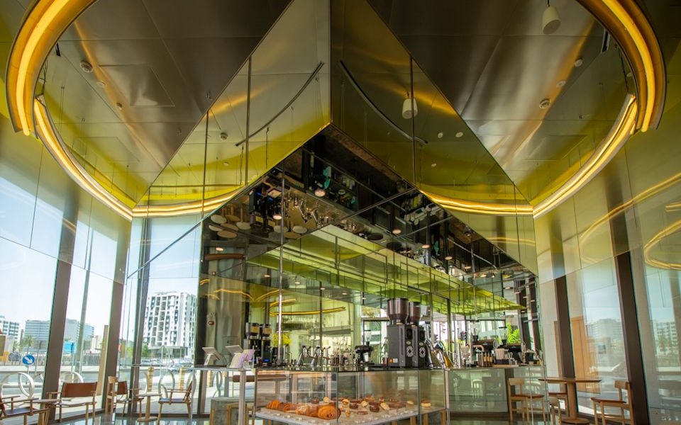 Specialty coffee bar with mirrored canopy and illuminated ring ceiling, F&B fit-out by Interprogetti in Doha, Qatar
