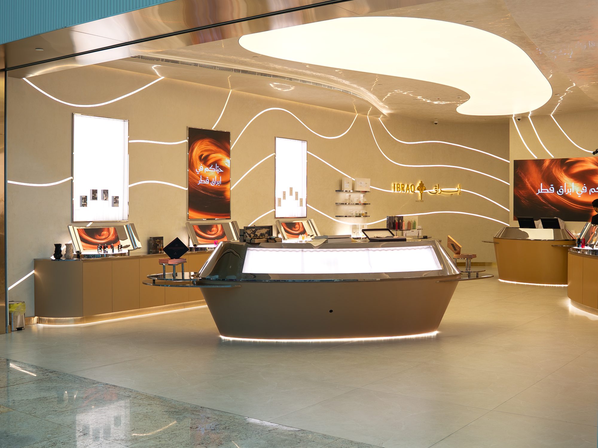 Ibraq perfume store interior with central display counter and linear wall lighting, fit-out by Interprogetti