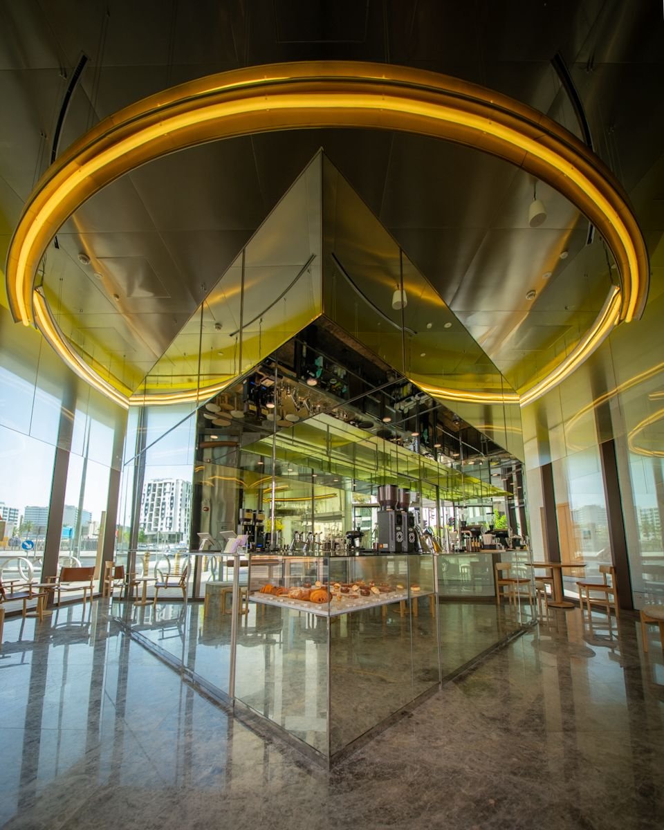 Le Petit Camion Msheireb coffee bar with mirrored canopy, illuminated ring ceiling and glass pastry display, fit-out by Interprogetti